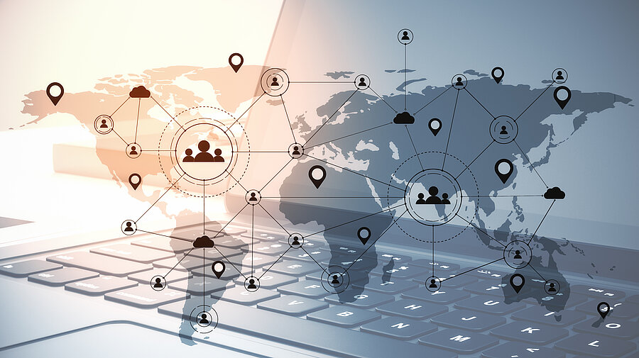 Weltkarte mit verbundenen Standortsymbolen und einer Laptoptastatur im Hintergrund